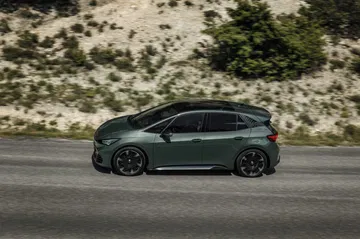 Vista dinámica lateral del Cupra Born VZ en movimiento, destacando su diseño aerodinámico.