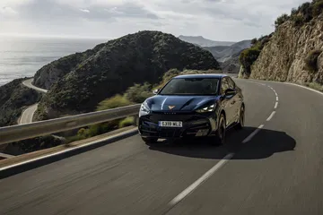 Vista dinámica del CUPRA Tavascan VZ circulando por carretera de montaña