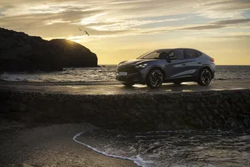CUPRA Tavascan VZ exhibiendo su perfil lateral deportivo al atardecer