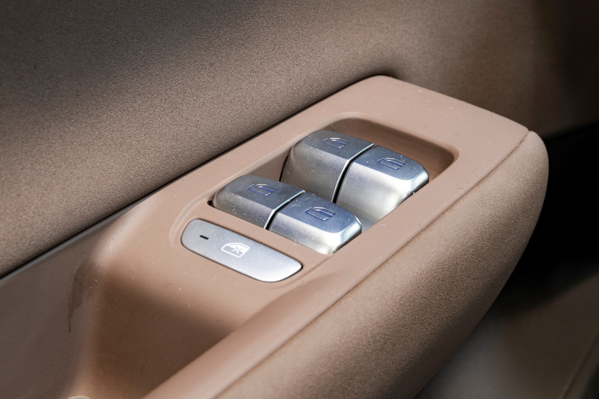 Detalle de los mandos de ajuste de asiento en cuero marrón
