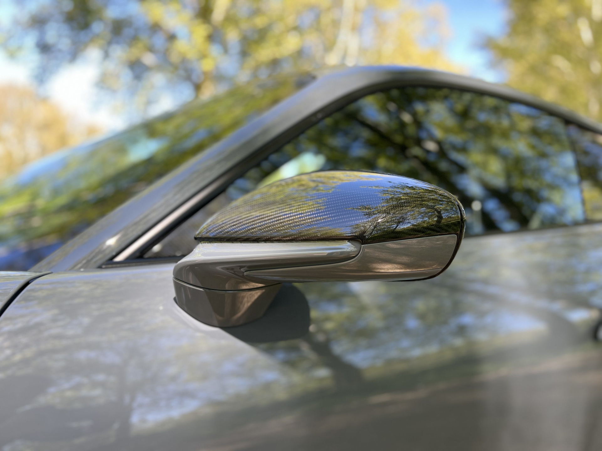 Detalle del espejo retrovisor lateral en fibra de carbono del Porsche 911 GT3 Touring.