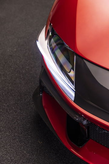 Primer plano del imponente frontal de un Ferrari, destacando su sofisticada óptica y aerodinámica.