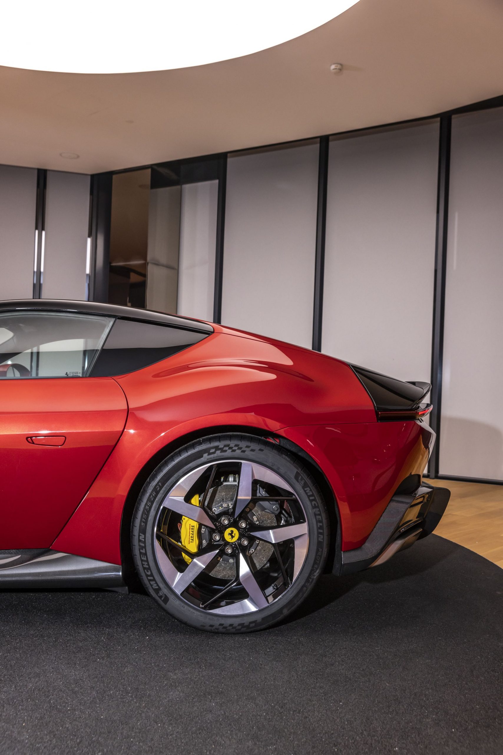 Vista trasera-lateral del Ferrari, destacando su diseño aerodinámico y llantas deportivas.