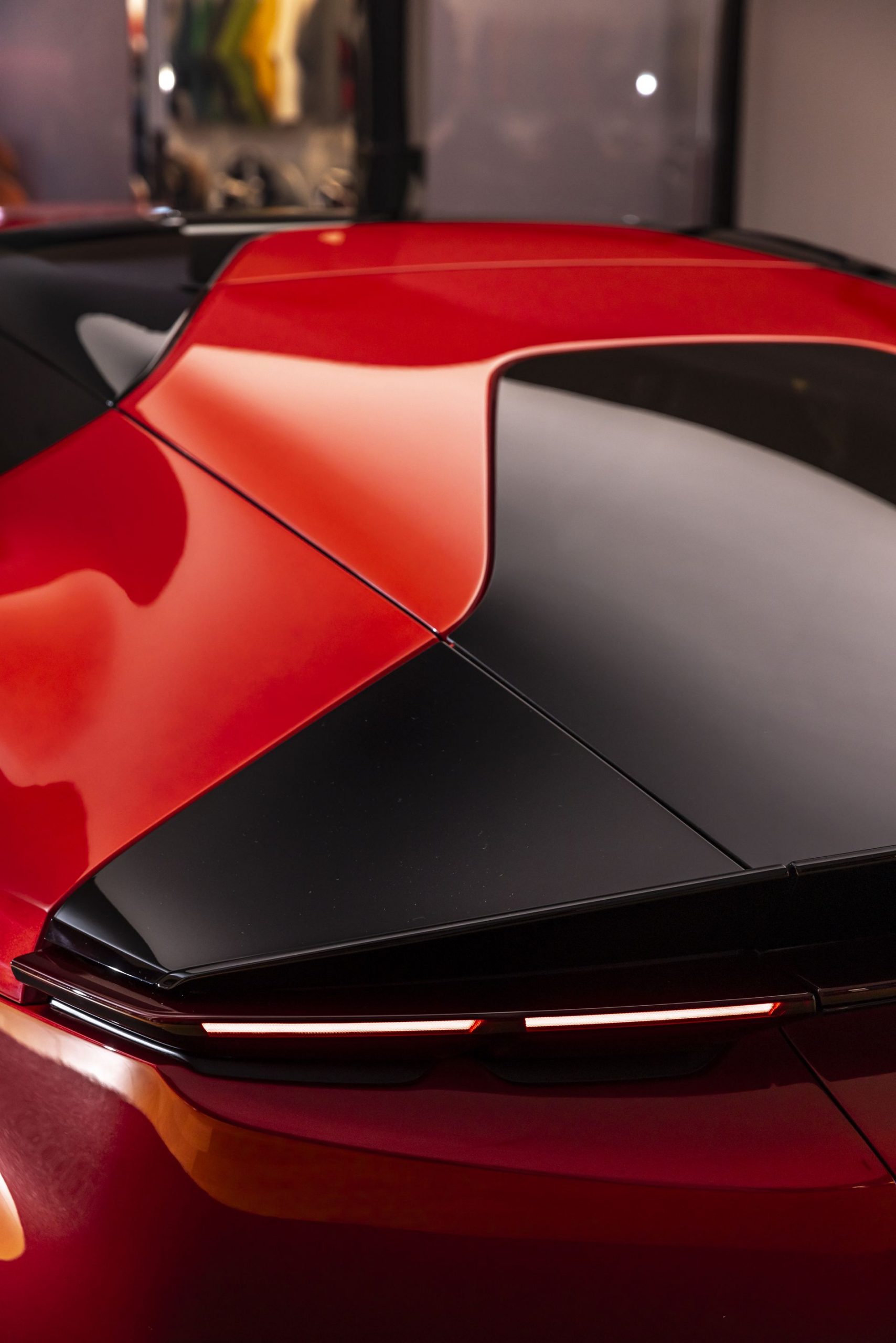 Vista trasera del Ferrari con enfoque en la elegante fusión de colores y líneas aerodinámicas.
