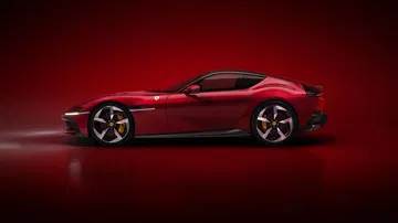 Vista lateral del Ferrari con diseño aerodinámico y vanguardista, destacando su perfil deportivo.