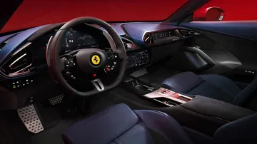 Vista del lujoso habitáculo delantero del Ferrari, destacando su elegancia y tecnología avanzada.