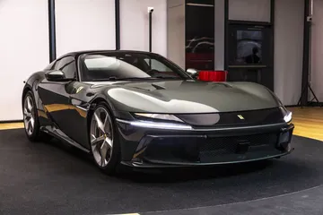 Vista frontal y lateral del Ferrari, mostrando su diseño aerodinámico y la distintiva parrilla.