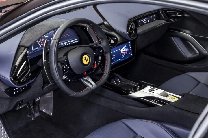 Vista del volante y panel de instrumentos de un Ferrari, finos acabados y tecnología de punta reflejan su esencia deportiva.