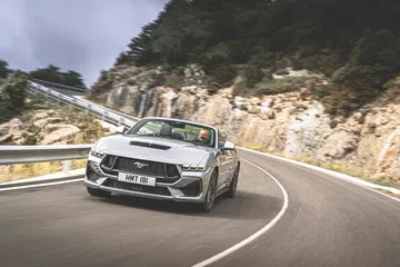 El Ford Mustang 2024 exhibe su línea clásica y potente en curvas cerradas.