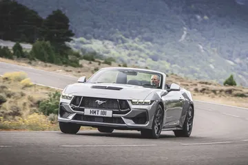 Vista dinámica del Ford Mustang 2024 resaltando su robusto frente y perfil lateral.