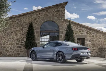 Vista lateral del icónico Ford Mustang 2024 en un entorno urbano.