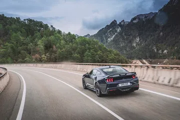 Vista dinámica del Mustang 2024 perfilando con maestría las curvas del asfalto.