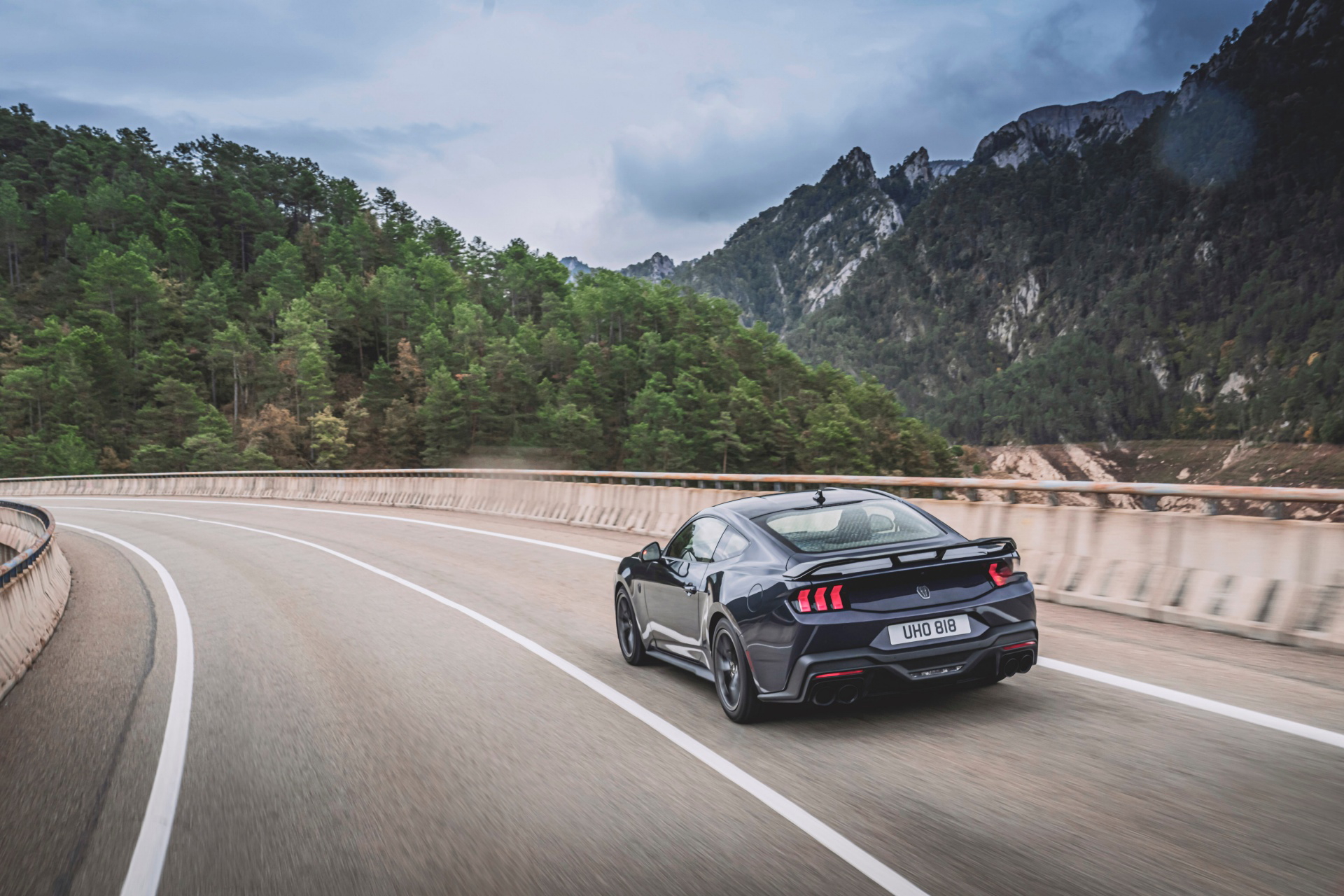 Vista dinámica del Mustang 2024 perfilando con maestría las curvas del asfalto.