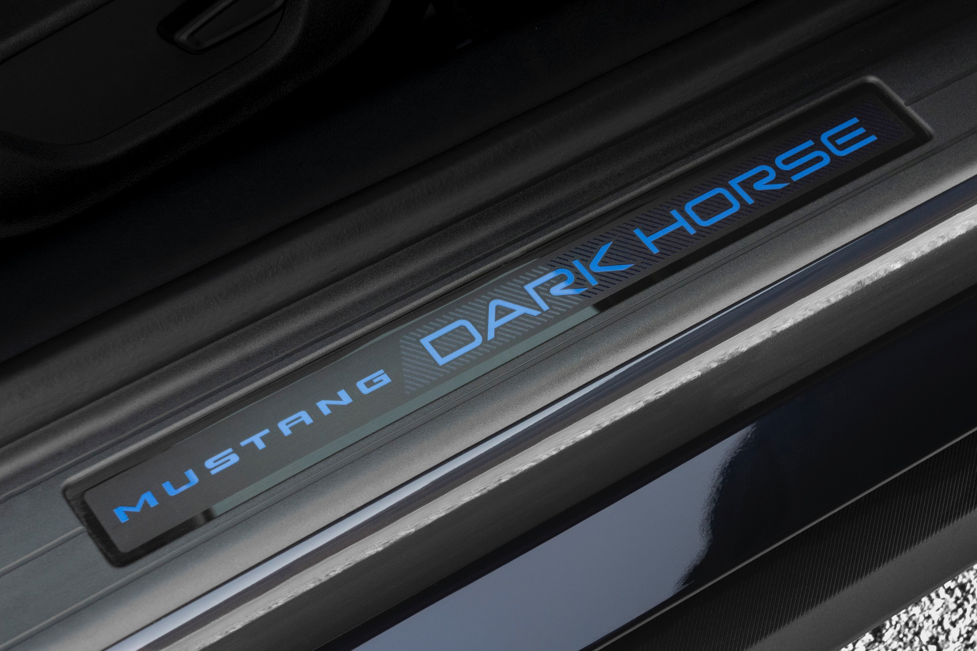 Umbral de puerta iluminado del Ford Mustang 2024 con inscripción distintiva.
