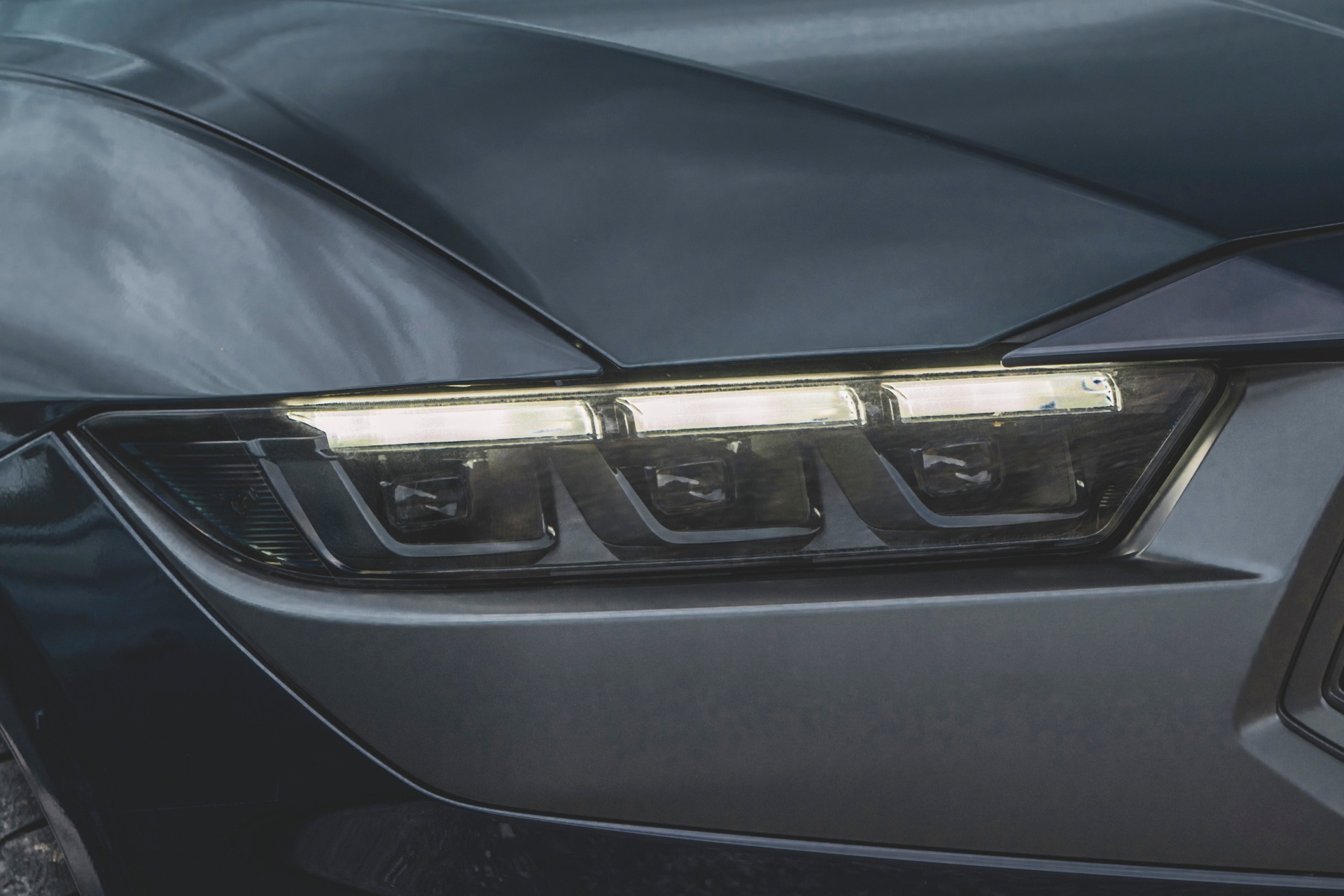 Vista cercana de las luces delanteras del Ford Mustang 2024, diseño agresivo y moderno.