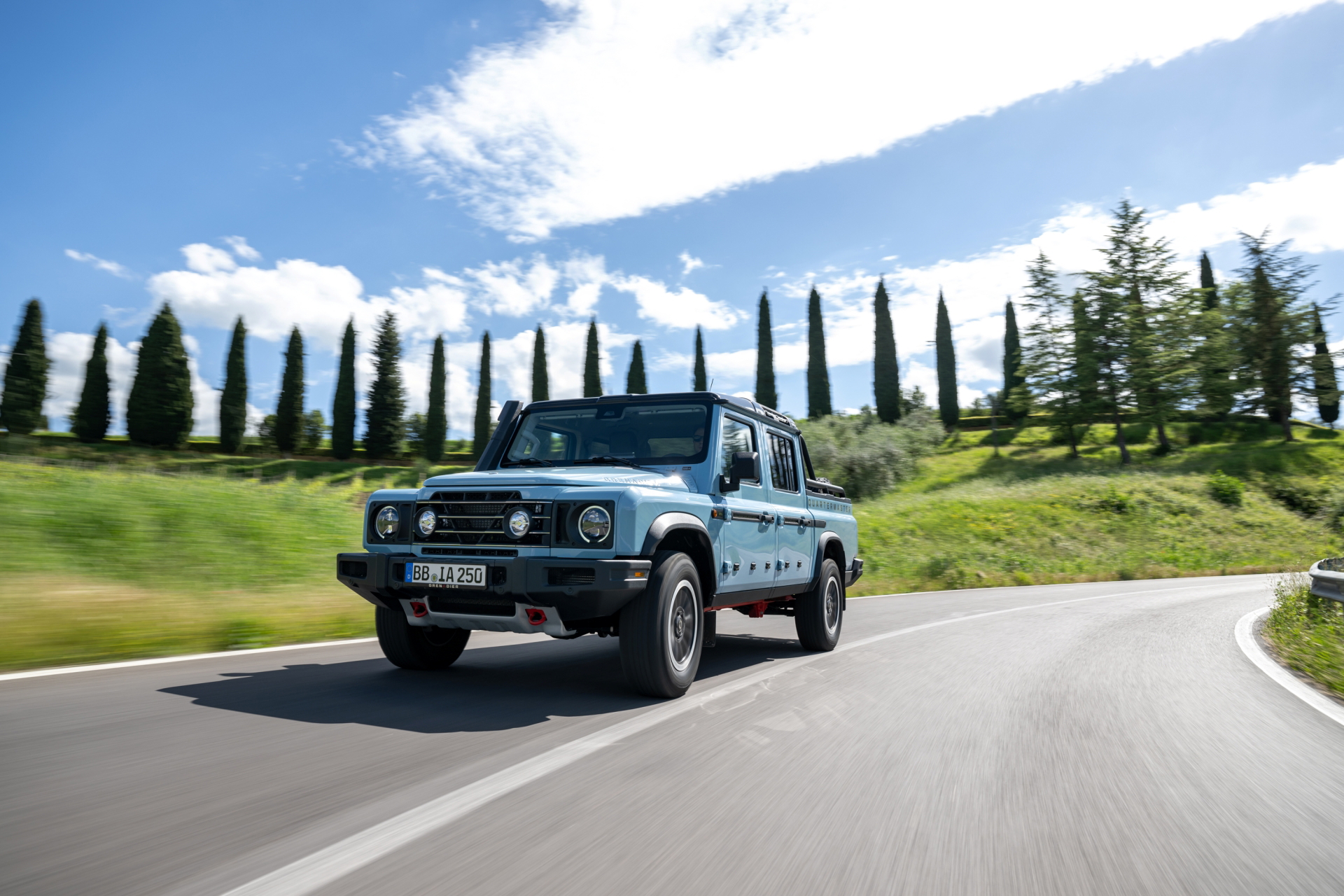 El Ineos Grenadier muestra su robusta silueta en una imponente carretera.