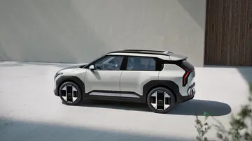 Vista lateral del KIA EV3 en color blanco, destacando su diseño moderno y líneas aerodinámicas.