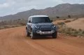 Vista dinámica del Land Rover Defender 2024 en terreno árido.