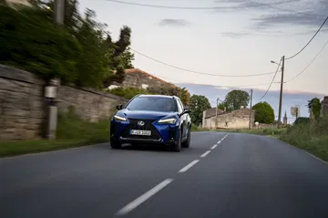 El Lexus UX 300h 2024 en acción, mostrando su estilizada silueta y frontal dinámico