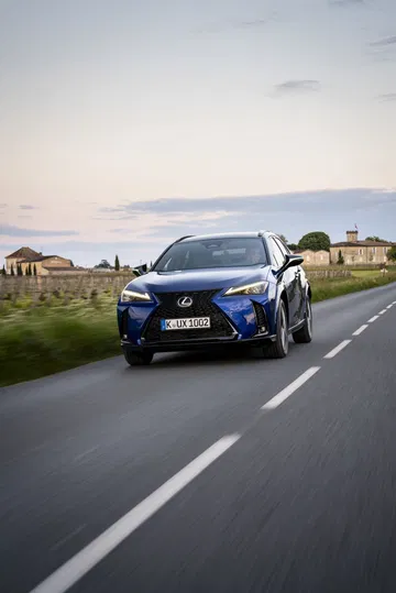 Vista dinámica del Lexus UX 300h 2024 recorriendo una carretera