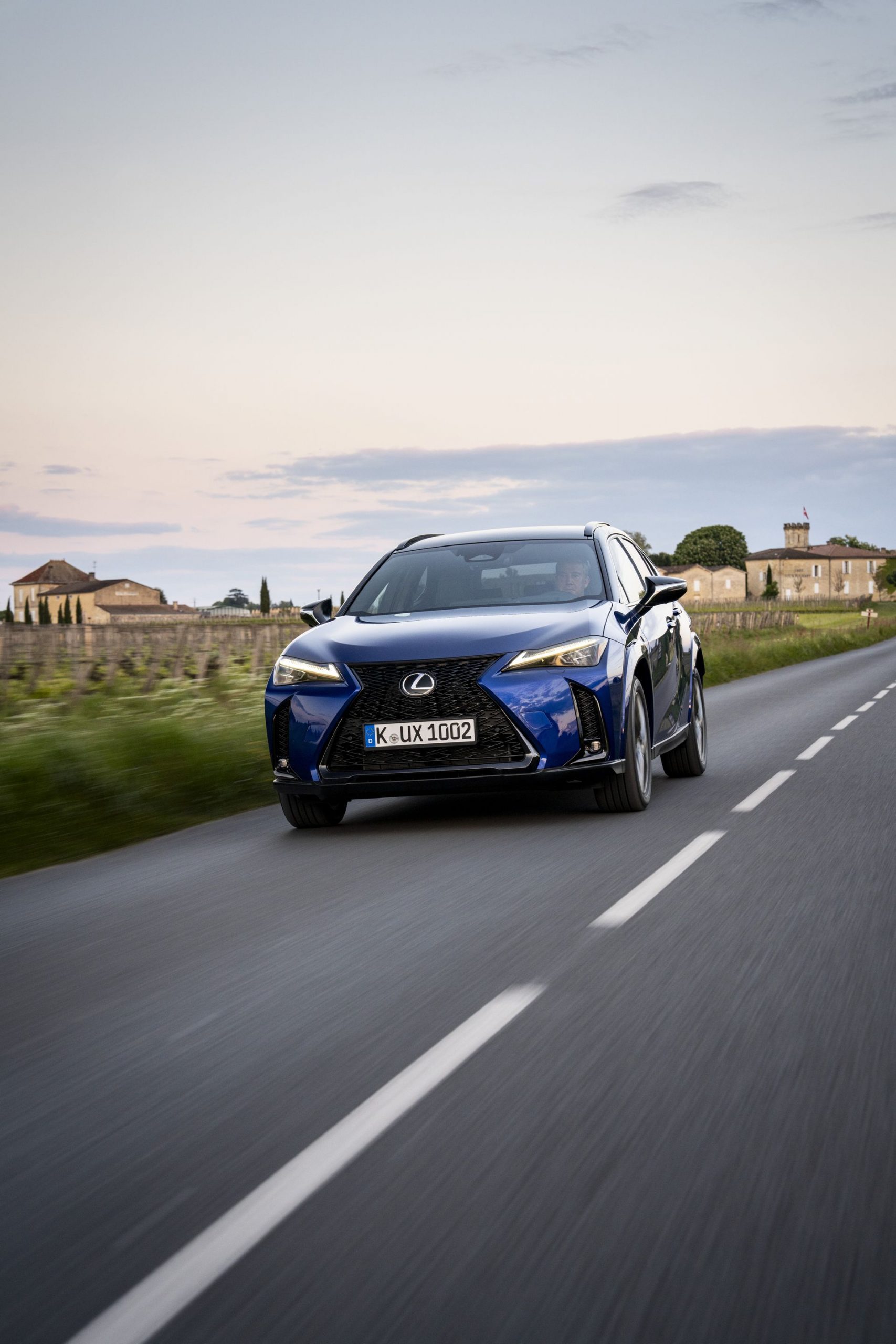 Vista dinámica del Lexus UX 300h 2024 recorriendo una carretera