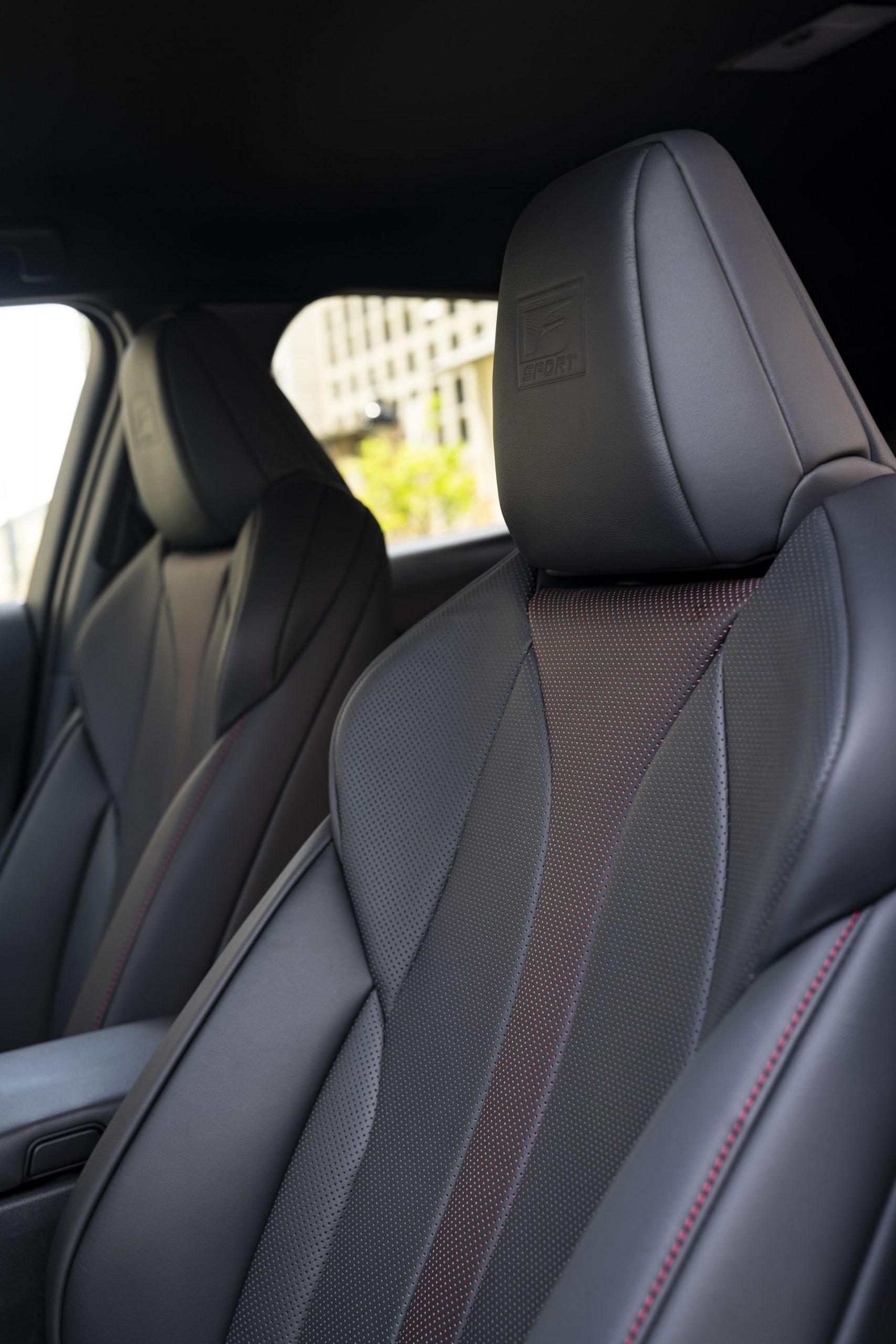 Vista detallada de los asientos delanteros del Lexus UX 300h, destacando su tapicería y acabados.