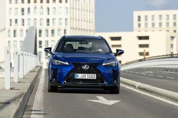 Vista frontal del Lexus UX 300h 2024 en movimiento, reflejando su diseño dinámico.