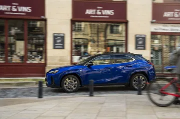 Vista lateral del Lexus UX 300h, destacando su diseño dinámico y urbano.