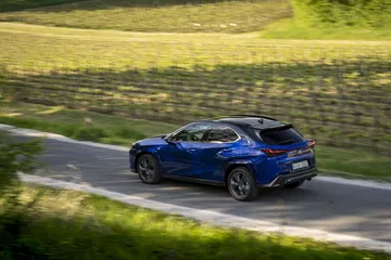 El Lexus UX 300h 2024 demuestra su estilizada silueta y su elegante diseño lateral en movimiento.