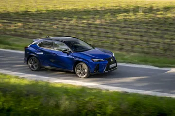 Vista dinámica lateral del Lexus UX 300h 2024 en carretera