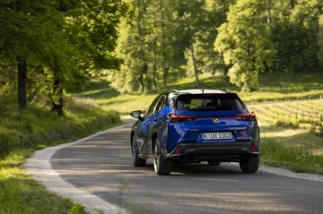 Vista dinámica del Lexus UX 300h mostrando su línea y la trasera en movimiento