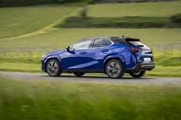 Vista dinámica del Lexus UX 300h en movimiento, destacando su perfil elegante.