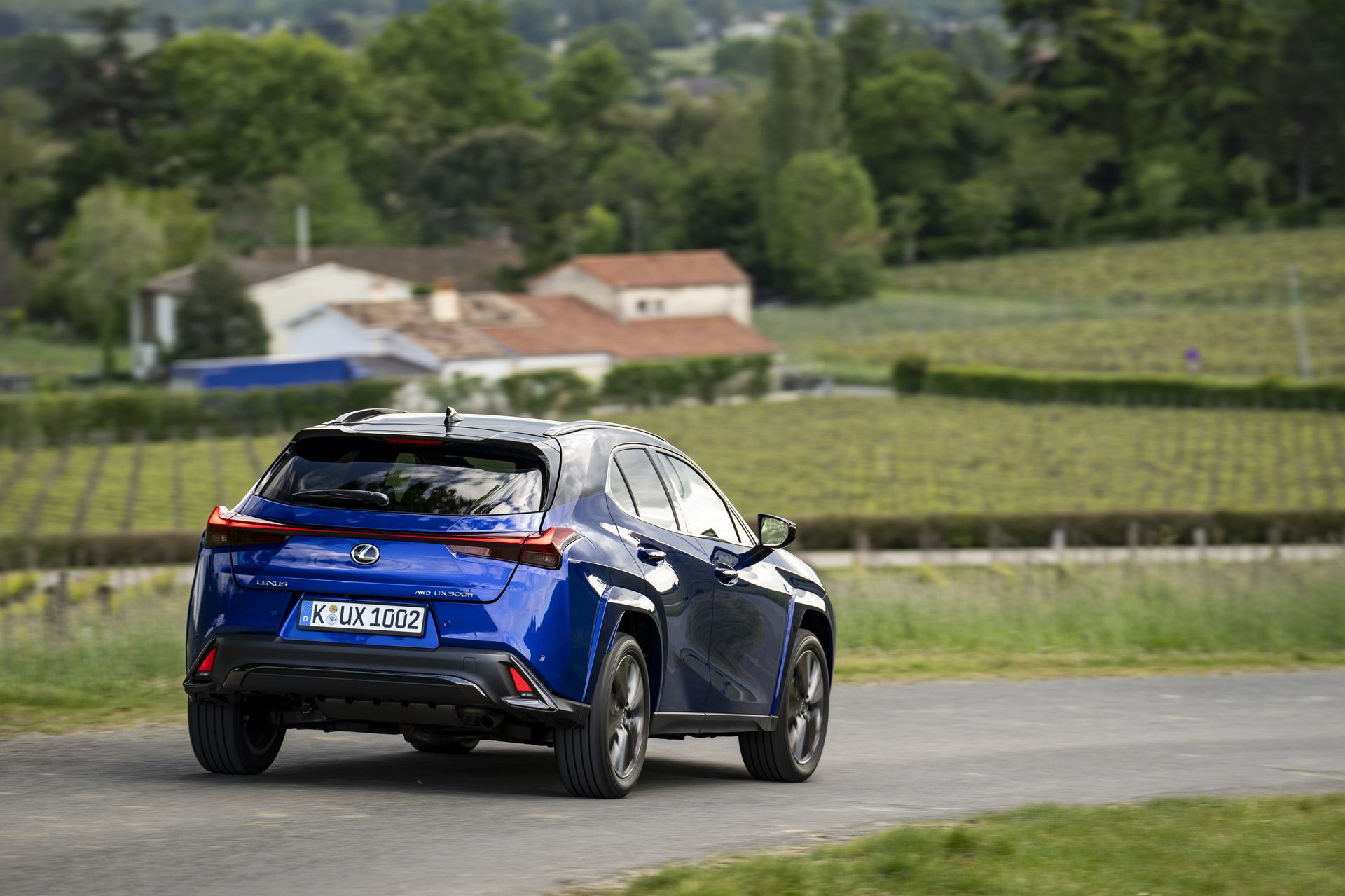 Vista lateral del Lexus UX 300h en movimiento, destacando su silueta aerodinámica.
