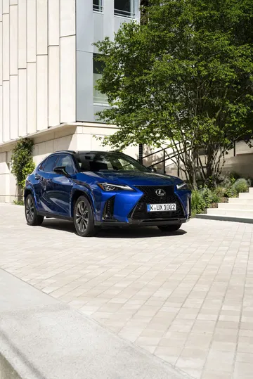 Un Lexus UX 300h en entorno urbano, mostrando su frontal dinámico y líneas laterales.