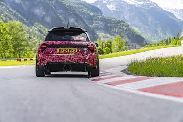 Vista trasera dinámica del Mini JCW en circuito, destacando su diseño deportivo.