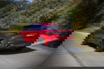 Vista dinámica de un SUV compacto en color rojo, destacando su diseño moderno y líneas aerodinámicas.
