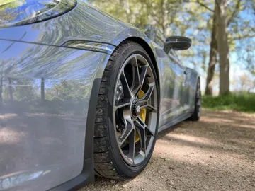 Vista lateral del Porsche 911 GT3 Touring enfocando llanta y carrocería.