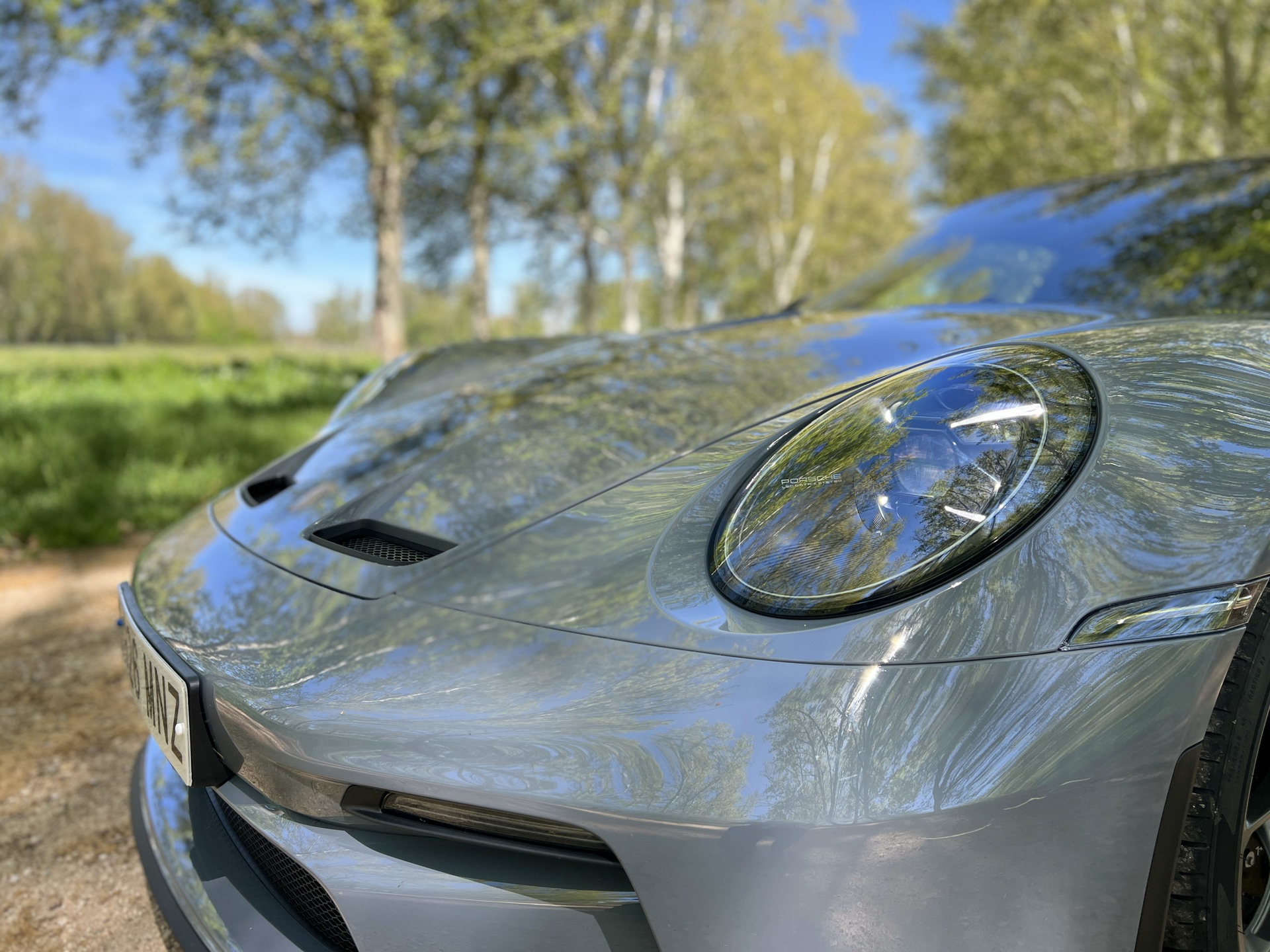 Vista detallada de la parte delantera del Porsche 911 GT3 Touring, destacando sus faros y tomas de aire.
