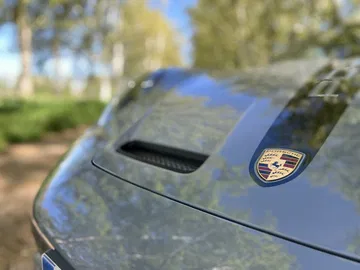 Insignia Porsche sobre capó azul mostrando la exclusividad del 911 GT3 Touring.
