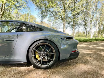 Vista lateral y trasera del Porsche 911 GT3 Touring, exhibiendo su perfil y llantas deportivas.