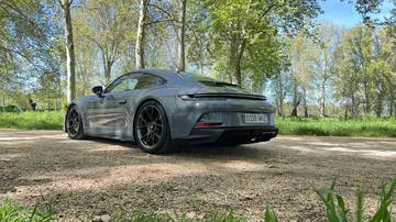 Vista angular trasera del Porsche 911 GT3 Touring aparcado en entorno natural.