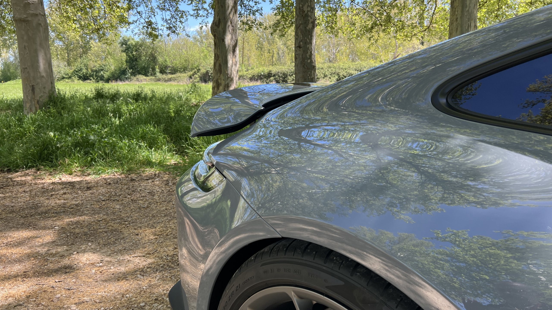 Vista lateral del Porsche 911 GT3 Touring aparcado en un entorno natural.