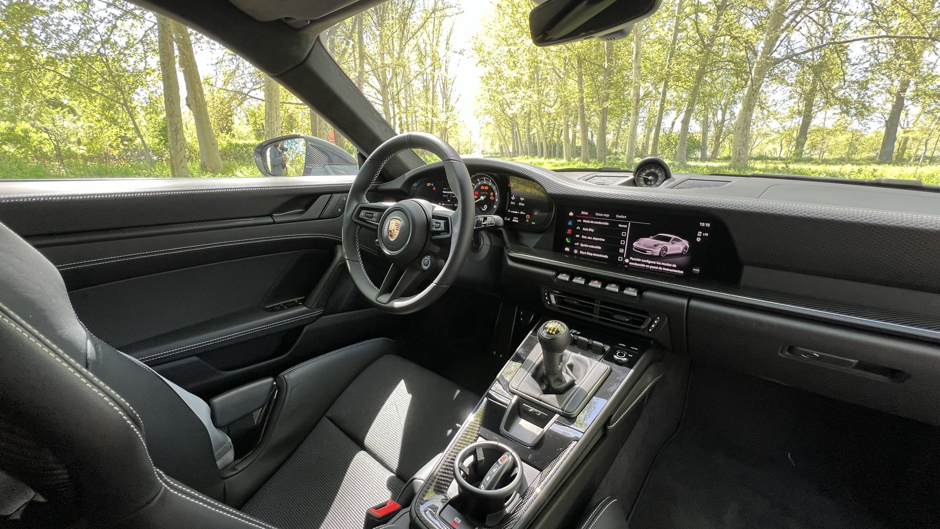 Cabina del Porsche 911 GT3 Touring destacando volante y asientos deportivos.