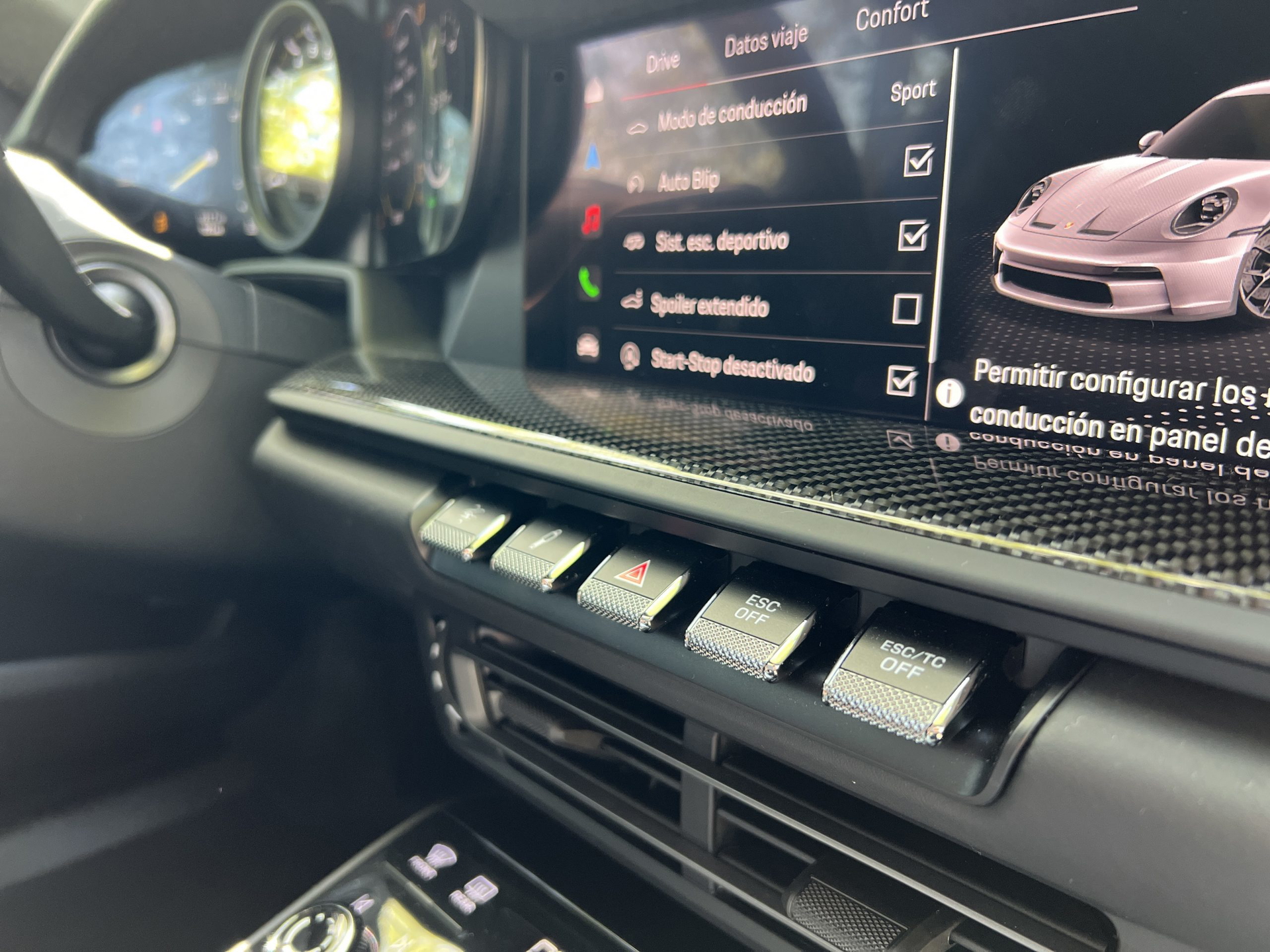 Vista enfocada de la consola central del Porsche 911 GT3 Touring, mostrando botones de control deportivo.