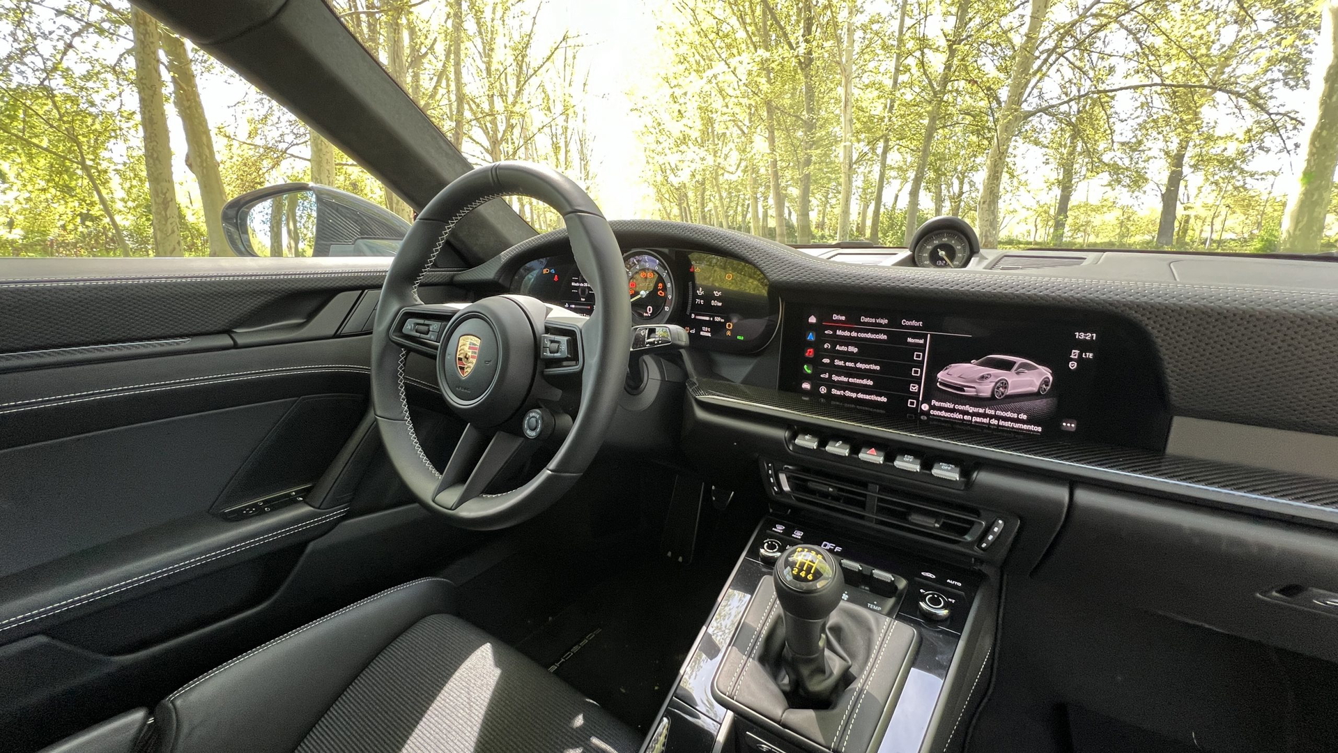 Vista interna del Porsche 911 GT3 Touring mostrando su elegante cabina y volante.