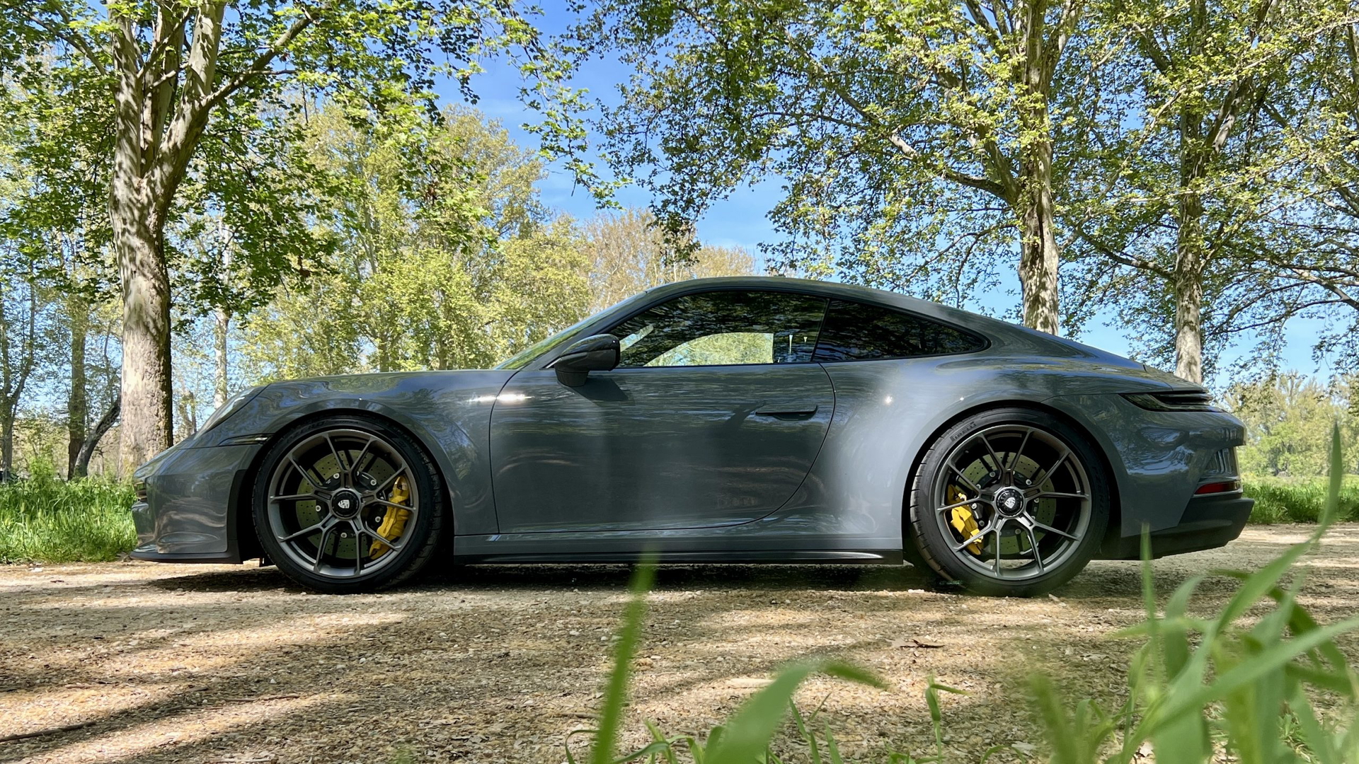 Vista lateral Porsche 911 GT3 Touring, destacando su diseño aerodinámico y llantas deportivas.