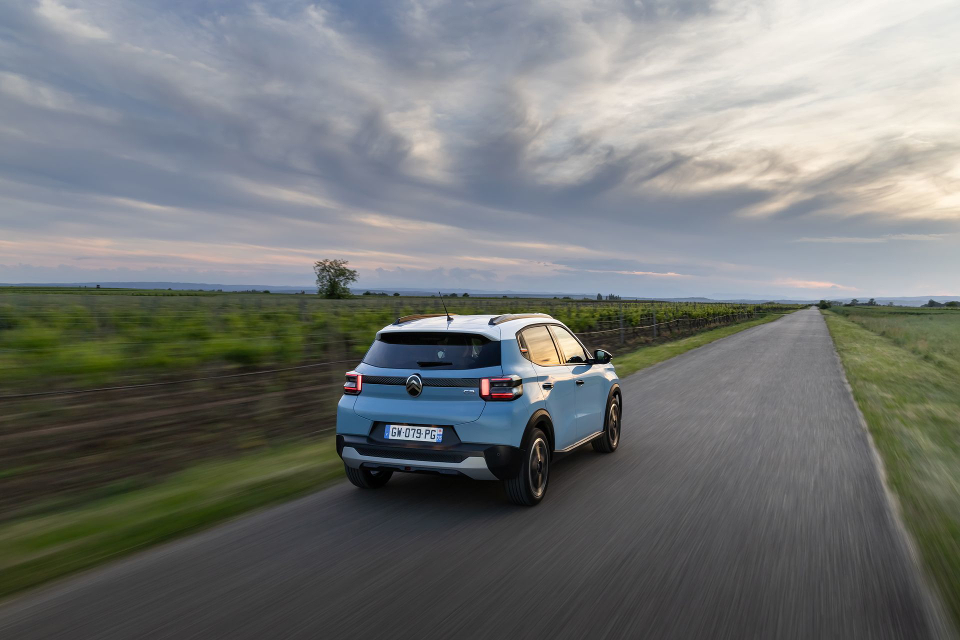 Vista dinámica del Citroën C3 en carretera, mostrando su línea y diseño trasero.