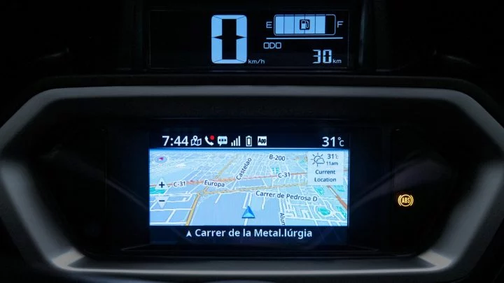 Vista cercana del sistema de infotainment mostrando navegación GPS activa y detalles del vehículo.