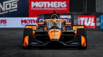 Monoplaza Arrow McLaren IndyCar, vista frontal en circuito, destacando aerodinámica avanzada.