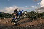 Motorista elevando rueda delantera Yamaha Ténéré 700 en terreno off-road